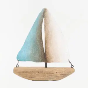Velero decorativo de madera con velas de metal blancas y turquesas