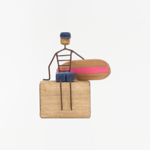 Figura de surfero sentado de metal y madera